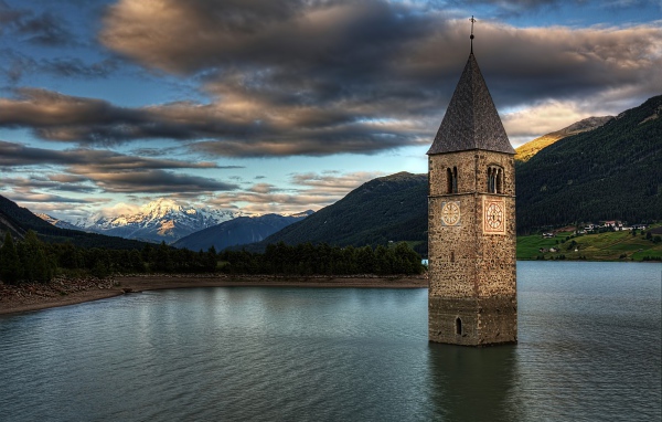 An ancient chapel in the background of a beautiful sky in the middle of Lake Rezia, Italy