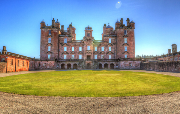 Замок Drumlanrig Castle с зеленым  газоном, Шотландия 