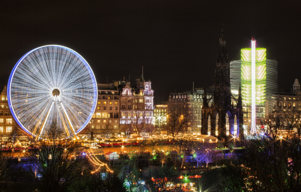 Ferris wheel in the evening against the background of the city of Edinburgh, Scotland