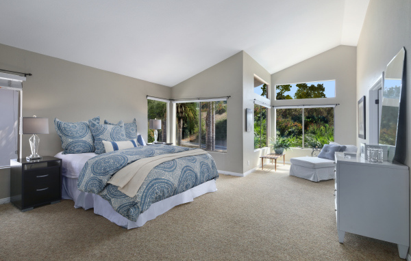 Уютная спальная комната в серых тонах с большими окнами