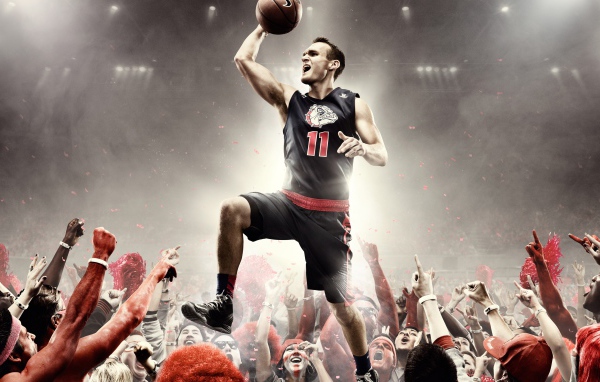 Баскетболист в прыжке над толпой 