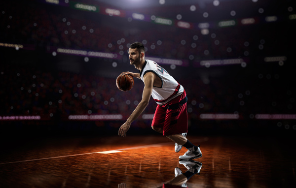 Баскетболист с мячом играет на поле