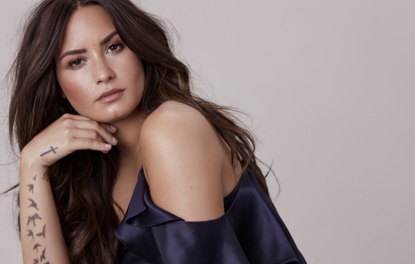 Знаменитая актриса, певица Деми Ловато фото на сером фоне