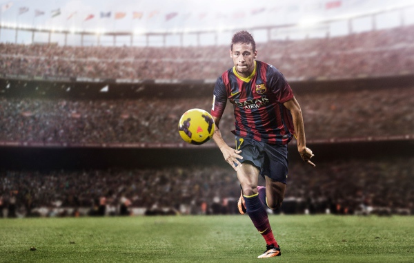 Футболист Неймар на футбольном поле с мячом