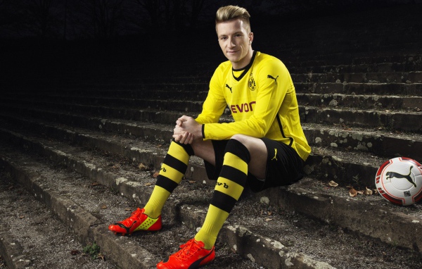 Немецкий футболист Марко Ройс сидит на ступеньках 