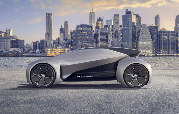 Серебристый электрический автомобиль  Jaguar Future-Type на фоне небоскребов