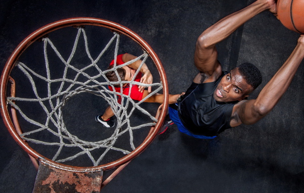 Баскетболист забрасывает мяч в кольцо 