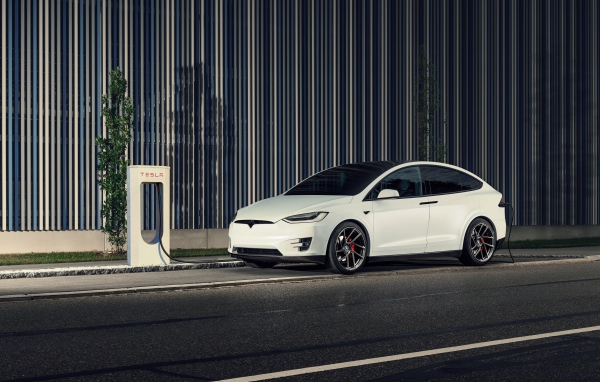 Белый электрокар Tesla Model X на заправке
