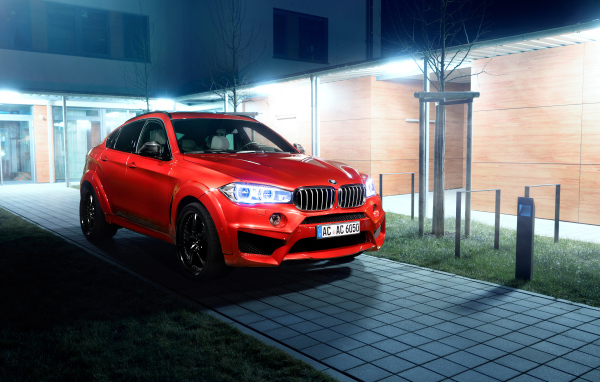 Красный автомобиль BMW X6 на тротуаре