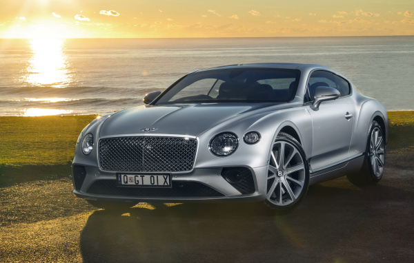 Серебристый Bentley Continental GT 2018 года на фоне моря