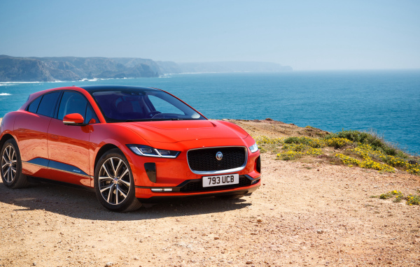 Красный Jaguar I-Pace EV400 AWD HSE First Edition 2018 года на фоне океана 