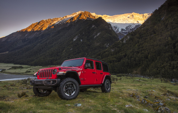 Красный автомобиль Jeep Wrangler на фоне гор