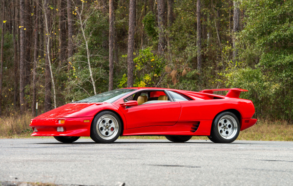 Красный спортивный автомобиль Lamborghini Diablo на фоне леса