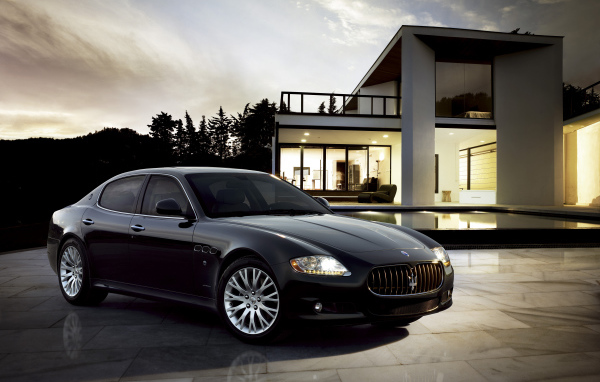 Черный автомобиль  Maserati Quattroporte у большого дома