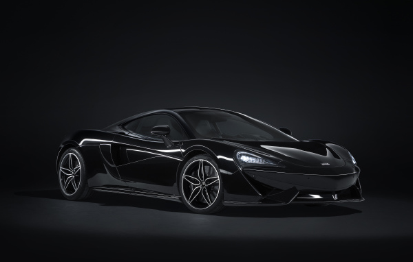 Черный автомобиль McLaren 570GT на сером фоне