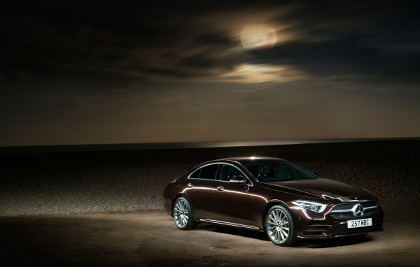 Коричневый автомобиль Mercedes Benz CLS 400 D AMG 2018 года на фоне луны