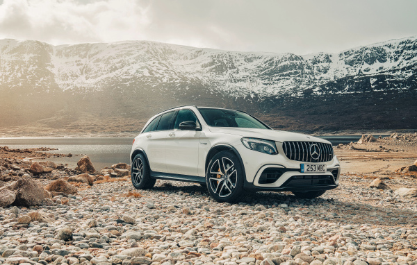 White SUV Mercedes AMG GLC 63 S, 2018 against the backdrop of the mountains