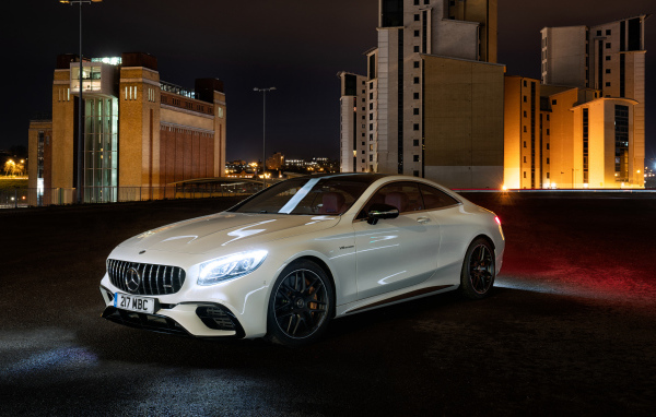 Белый автомобиль Mercedes AMG S 63 4MATIC Coupe, 2018 года на фоне города
