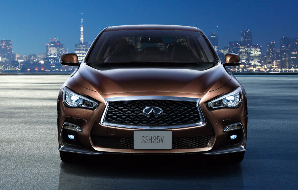 Коричневый автомобиль Nissan Skyline Hybrid, 2018 на фоне ночного города