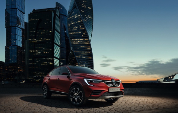 Cross-country Renault Arkana, 2019 against the backdrop of a megacity