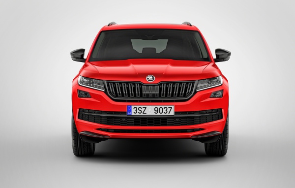 Красный автомобиль Skoda Kodiaq на сером фоне