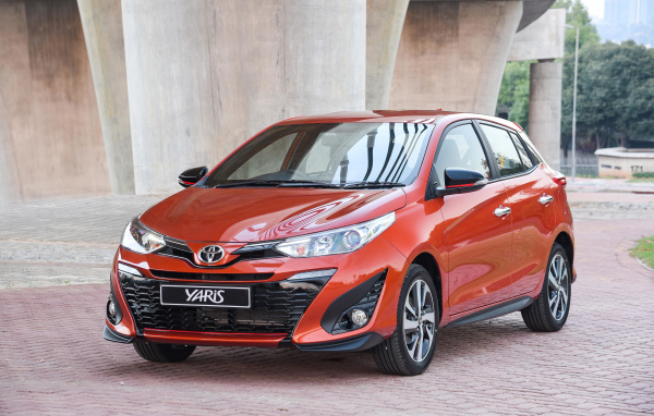 Красный автомобиль Toyota Yaris под мостом 