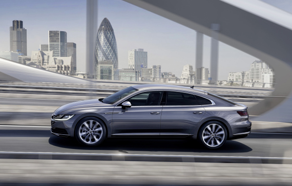 Серебристый автомобиль Volkswagen Arteon, 2018 года на фоне города