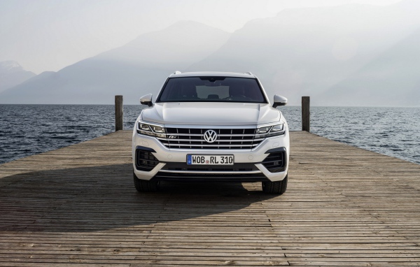Белый автомобиль Volkswagen Touareg, 2018 года на мосту
