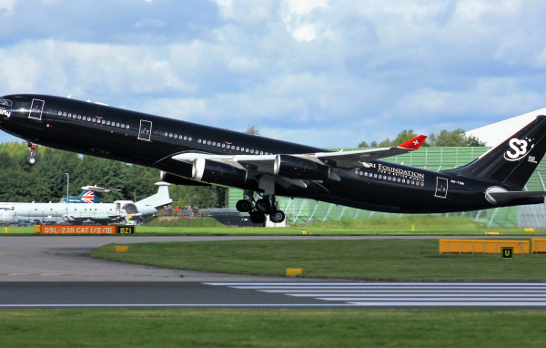 Черный пассажирский самолет Airbus A340-313 на взлете