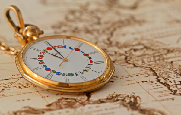 Карманные часы в золотой оправе лежат на карте