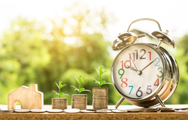 Будильник с монетами с зелеными ростками