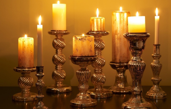 Старинные подсвечники с зажженными свечами на столе 