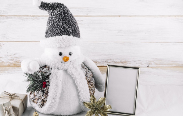 Большой игрушечный снеговик на деревянном фоне