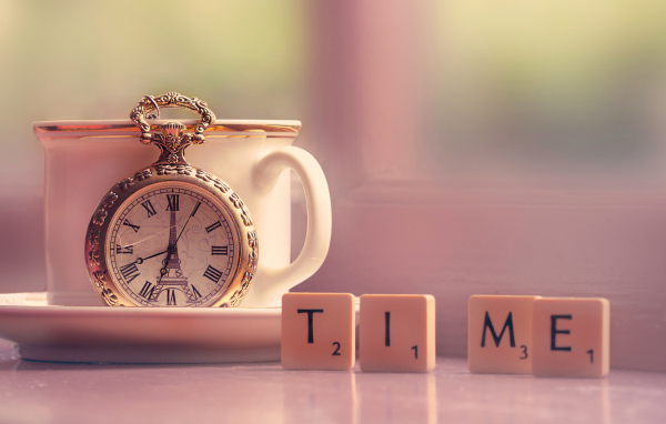 Часы с чашкой на столе с кубиками 