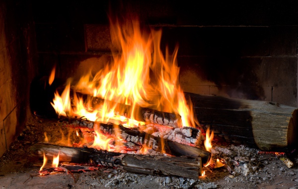 Дрова горят ярким пламенем в камине