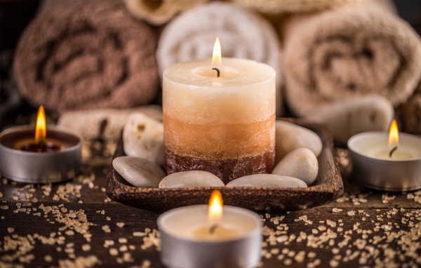 Зажженная свеча с камнями для SPA процедур