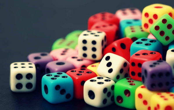 Разноцветные игральные кости на сером столе 