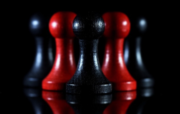 Красные и черные шахматные фигуры на черном фоне