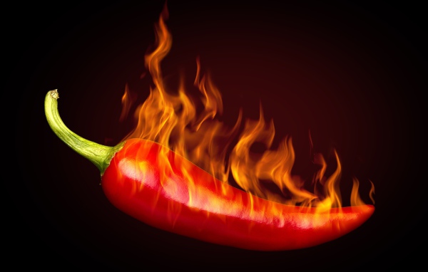 Красный перец с пламенем на черном фоне
