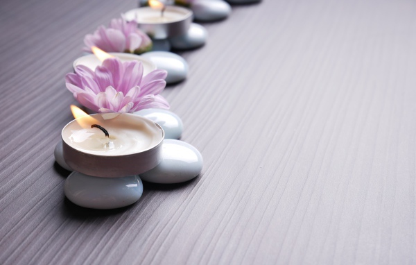 Камни с ароматическими свечами и цветами хризантемы