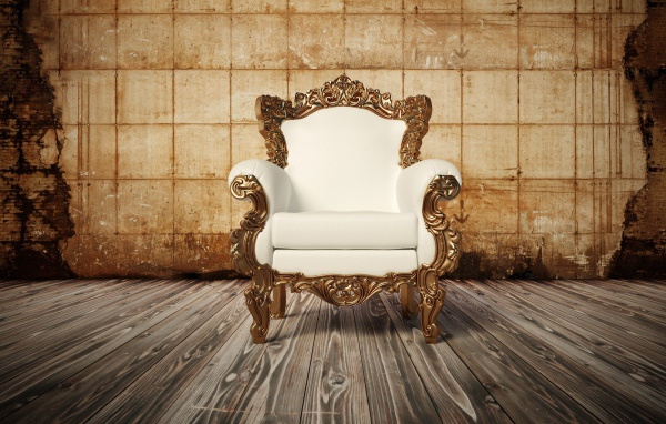 Белое новое кожаное кресло на деревянном полу у старой стены