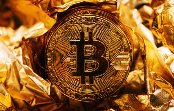 Золотая монета биткоин на фольге