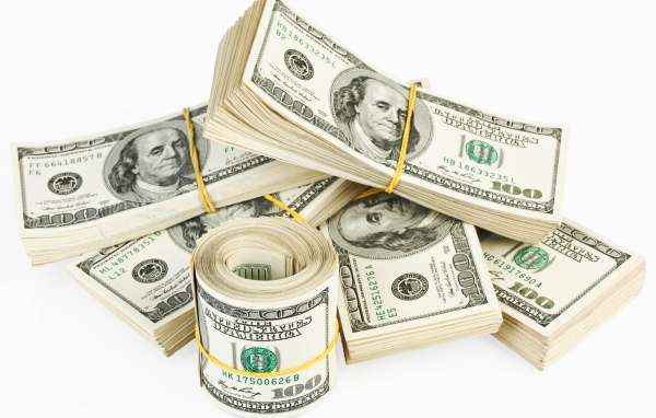 Пачки банкнот по сто долларов на белом фоне