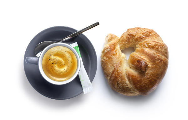 Круассан и чашка кофе на белом фоне