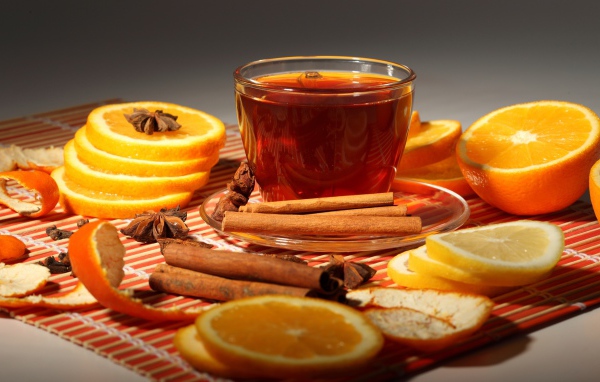 Чашка чая на столе с апельсинами, корицей и бадьяном