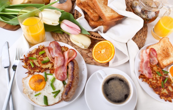 Сытный завтрак на столе с букетом тюльпанов 