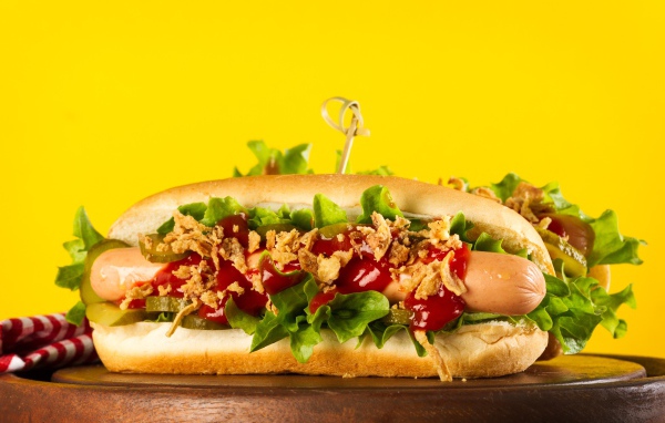 Аппетитные хотдоги на желтом фоне крупным планом