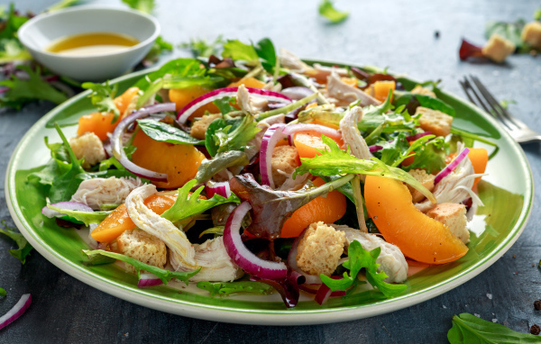 Аппетитный салат с курицей на большой тарелке