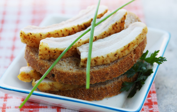 Черный хлеб с салом и зеленью на столе