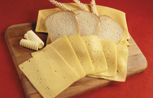 Хлеб с кусками сыра на разделочной доске